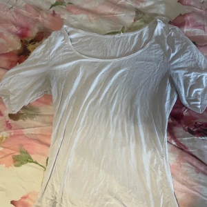 Vit enkel kortärmad topp - En basic vit topp med rund halsringning och korta ärmar (som jag har klippt, syns inte att man har klippt om man har på den)  Modellen är figurnära och i ett mjukt, tunt material som känns skönt mot huden. Perfekt att styla med jeans eller kjol för en clean look.