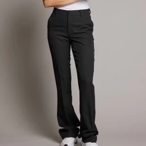 Svarta kostymbyxor med bootcut - Snygga svarta kostymbyxor med bootcut-snitt och klassisk passform och är högmidjade. 