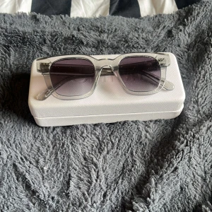 CHIMI 04 - Snygga solglasögon från CHIMI med grå båge och fyrkantig form. Modell 04. Glasen är mörktonade och ger en cool vibe. Kommer med originalfodral och putsduk. Perfekta för dig som vill sticka ut med stilrena accessoarer. Nypris 1400:- skick helt okej, normalt slitage på båge och glas, låda sliten och smutsig rekommenderar att använda en annan men skickar naturligtvis med den.