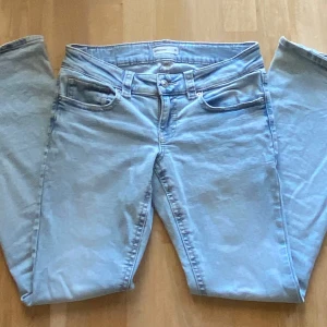 Ljusblå lågmidjade bootcut jeans från Gina Tricot strl 38 - Jag säljer ett par ljusblå jeans från Gina Tricot i storlek 38, modell y2k low bootcut. Jeansen har låg midja och utsvängda ben med snygga backfickor.