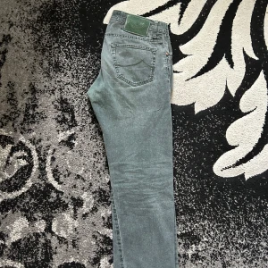 Jacob Cohën jeans, stl 32 - Snygga grå jeans från Jacob Cohën i klassisk femficksmodell. Jeansen har raka ben och normal passform, tillverkade i mjuk bomull med en lätt tvättad look. Perfekta för dig som gillar stilrena och bekväma byxor med italiensk känsla.
