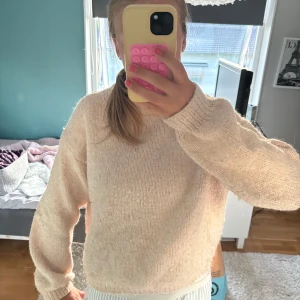 Rosa stickad tröja från H&M - Mysig ljusrosa stickad tröja från H&M med hög ribbad halsringning. Tröjan har lång ärm och en rak, något loose passform. Perfekt för kyliga dagar och enkel att matcha med olika outfits.