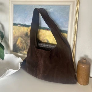 ARKET SUEDE BAG SLUTSÅLD ÄKTA MOCKA - INTRESSEKOLL!! Slutsåld mocka väska från Arket, inköpt ca ett år sedan för 2290kr. Skick enligt bild, mocka är levande material och ändrar därmed något i färg och textur efter tid av användning 🤎 Finns en mindre fläck (se bild 3). Går säkerligen bort med rätt rengöring för mocka! Otroligt fin och efterfrågad. Borsta med mockaborste och den blir som ny. Färg BROWN. Perfekt som skolväska eller jobbväska ☕️
