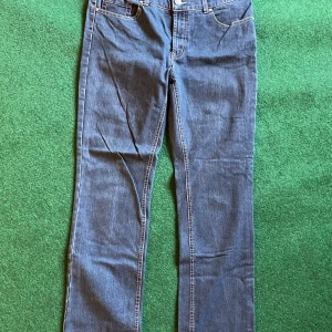 Blå raka jeans  - Klassiska blå jeans lite mörkare från Denim Regular i rak modell med regular fit. Byxorna har fem fickor, normal midja och snygga kontrastsömmar. Perfekta för dig som gillar en tidlös och enkel stil. Materialet är slitstarkt jeans.