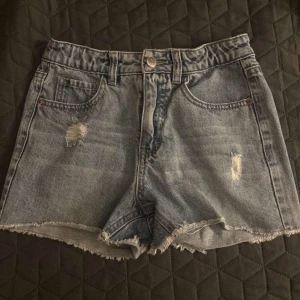 Grå jeansshorts med slitningar - Snygga grå jeansshorts från LAB Industries med hög midja, slitna detaljer och råa kanter. Klassisk femficksmodell med knapp och dragkedja framtill. Perfekta för en chill sommarlook. Inte storlek S det är 146/152
