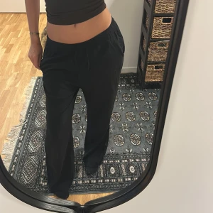 Svarta vida byxor med resårmidja - Säljer ett par svarta byxor med bred resår i midjan och raka, vida ben.