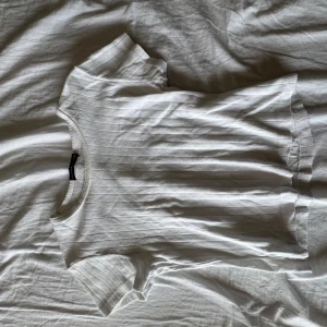 Vit ribbad topp från Brandy Melville - Supersöt vit ribbad topp från Brandy Melville med korta ärmar. Tunt, mjukt material den är croppad inte säker på storlek men skulle säg xs-S