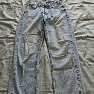 Ljusblå raka jeans Denim Rebel 36 - Ljusblå jeans från Denim Rebel i rak modell (Straight) med råa, fransiga benslut. Klassisk femficksdesign och normal passform. Jeansen är tillverkade i denim och har en avslappnad vibe, perfekta för en chill look. Jag kunde inte visa dem på eftersom de är för små.