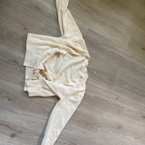 Kofta med rosett  - En beigevit kofta från hm i storlek 158/164