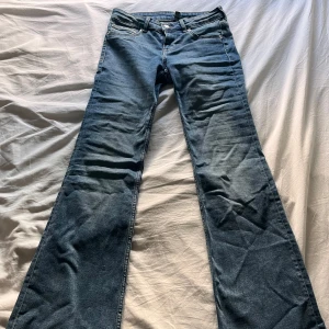 Lågmidjade bootcut jeans - Snygga mellanblå Lågmidjade jeans från Hm. De är aldrig använda då ja köpte fel storlek. Snygga basic jeans.