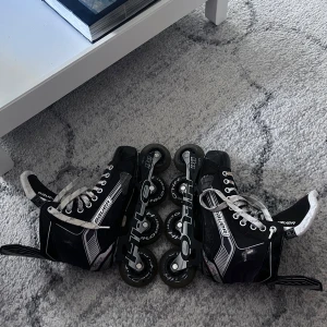 Svarta inlines från Bauer strl 40,5 - Säljer ett par svarta inlines från Bauer med vita detaljer och snörning. Skorna har robust design, högt skaft och slitstarka hjul från Hi-Lo. Perfekta för dig som vill glida fram på gatan med stil. Inlinesen är inte i jätte bra skick men går fortfarande att andvända.