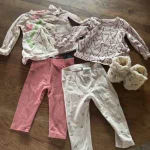 Rosa och vita leggings för barn - Ett barnkit med två par byxor och två par tröjor och ett tar tofflor. Det är storlek 74 och 80 och skorna är storlek 20