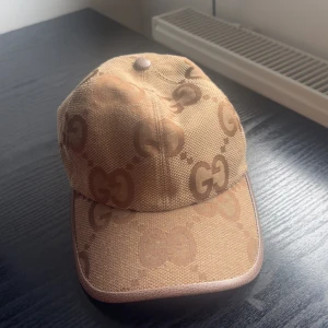 Beige keps från Gucci med GG-mönster - Beige Gucci jumbo keps. Har inte använts och är alltså i helt nytt skick. Säljer då denna kepsen inte är min stil riktigt.