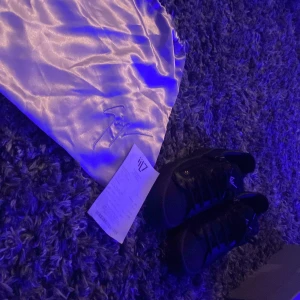 Svarta sneakers från Giuseppe Zanotti - Snygga svarta sneakers från Giuseppe Zanotti med signaturlogga på hälen och plösen. Skorna har snörning, dragkedja på sidan och platt sula. Tillverkade i skinn för en lyxig känsla. Perfekta för dig som vill ha en stilren och exklusiv look. (Äkta) köpte dom när ja va i Danmark kostade 4 tusen danska så ungefär nypris 6-7 tusen priset går att diskutera 