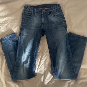 Blå jeans från Nudie Jeans - Säljer ett par blå jeans från Nudie Jeans med snygg tvätt. Jeansen är åt skinny hållet med måtten 28/32. Perfekta för dig som gillar en tidlös och avslappnad stil. Jeansen har används ca 3 gånger. Hör gärna av dig om du har några frågor