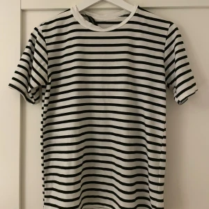 Randig t-shirt - Svart och vit randig t-shirt från PrettyLittleThing i storlek 34 Dam. Lappen håller på att ramla av men annars är tröjan i bra skick.