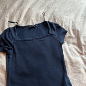 Mörkblå topp med fyrkantig ringning - Säljer en mörkblå topp från Gina tricot med korta ärmar och fyrkantig ringning💗💗toppen är använd flertal gånger men är i bra skick, Perfekt att styla med jeans eller en kjol💗 skriv vid frågor eller mer detaljerad bild💗 vill bara bli av med det så pris går såklart att sänkas💗