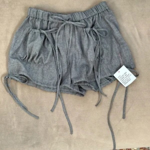 Grå linneshorts från Collusion - Snygga grå shorts från Collusion i luftig linnemix. Modellen är loose fit elastisk midja och flera snörningsdetaljer framtill och vid benen. 