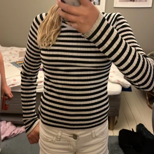 Randig ribbad tröja Gina Tricot S - Säljer en svartvit ribbad långärmad tröja från Gina Tricot i storlek S. Tröjan har klassiska horisontella ränder och är figurnära med stretchigt material. Perfekt till jeans eller kjol för en snygg och enkel look.