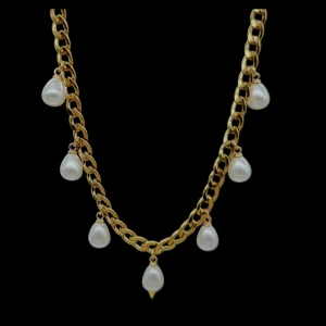 Guldfärgat halsband med pärldroppar - Stilrent halsband med chunky guldfärgad kedja och sju droppformade vita pärlor som hänger längs kedjan. Perfekt statement-piece för att lyfta din outfit med en elegant touch. Låset är klassiskt och smycket har en modern vibe.