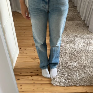 Ljusblå raka jeans från Gina Tricot  - Säljer ett par klassiska ljusblå jeans från Gina Tricot med rak passform och medel hög midja. Jeansen har fickor, gylf med dragkedja och är tillverkade i mjukt denim. Perfekta för en chill och stilren look.