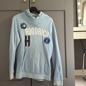 Ljusblå hoodie från Hoodrich - Säljer en ljusblå hoodie från Hoodrich för att den inte kommer till användning, den är i mycket bra skick saknar snöret till luvan annars inga defekter alls.