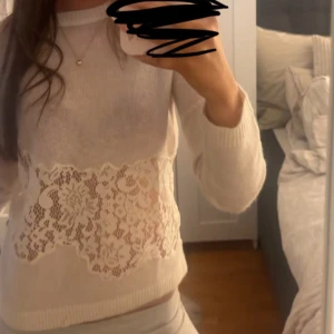 Vit stickad tröja med spetsdetalj - Super snygg och efterfrågad tröja! Spetsdetalj runt hela midjan både fram och bak🙌 Tunnt stickad super skön 💕storlek s men passar även xs bra
