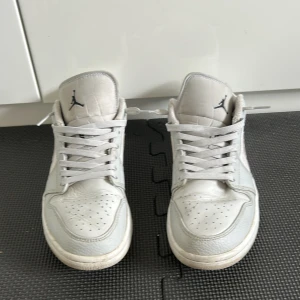Nike Air Jordan 1 Low i ljusgrått - Nike Air Jordan 1 Low sneakers i ljusgrått och vitt med klassisk Swoosh och Jumpman-logga. Ovandel i en mix av skinn och textil, perforerad tå och broderad vinge på hälen. Platt sula och snörning för en clean och sportig look. Dem är smutsiga men går att tvätta bord om man har rätt saker nypris 2800-3800 men säljer dom så billigt på grund av så smutsiga (ingen låda‼️)