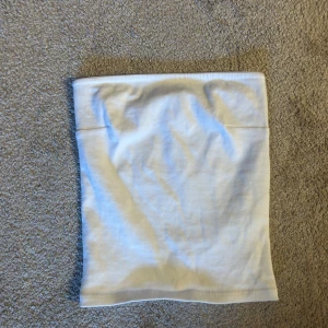Vit tubtopp från Gina Tricot - Säljer en vit, ribbad tub topp från Gina Tricot i storlek XXS. toppen är helt oanvänd och passar till allt.