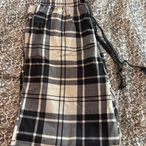 Mjukisbyxor H&M XS - Snygga rutiga mjukis från H&M i svart, grått och vitt. Byxorna har elastisk midja med snörning. Knappt använda, storlek XS