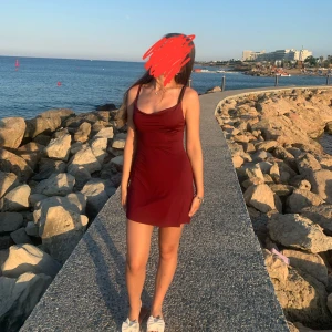 Vinröd kort klänning med draperad urringning - Supersnygg vinröd klänning med smala axelband och draperad urringning. Kort modell som sitter tight och har en stilren look. Perfekt för dig som gillar minimalistisk stil med en touch av elegans. Materialet är mjukt och följsamt, vilket gör den bekväm att bära.   (Skriv vid frågor) 🫶🏻