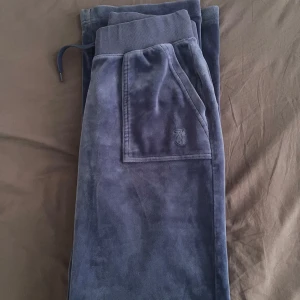 Blå velourbyxor Juicy Couture S - Säljer mina mysiga  blå mjukisbyxor från Juicy Couture i velour i S då jag inte använder de längre. Passar mig som är 167 cm lång och byxorna har inga defekter. Det går att diskutera priset. Skriv för mer bilder💕