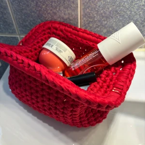 Rad handvirkad clutch  - Säljer en röd handvirkad clutch / handväska som jag har virkat! Väskan är i ett mjukt garn och är väldigt rymlig! Kan bäras i handen som en clutch eller bäras i handtaget.