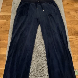 Mörkblå mjukisbyxor Juicy Couture L - Mörkblå mjukisbyxor från Juicy Couture i storlek L. Säljer då dom ej kommer till användning längre.