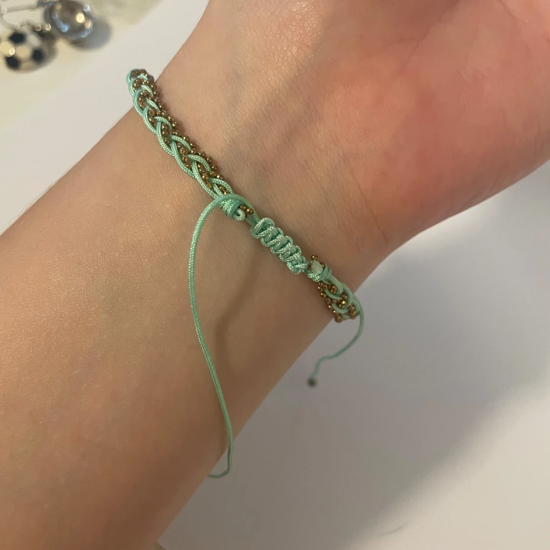 Flätat turkost fotlänk/armband med gulddetaljer - 1