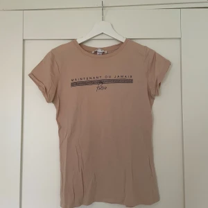 T-Shirt - Smuts rosa t-shirt med tryck. Storlek S. 100% bomull.