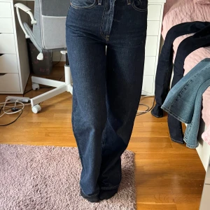 Levi's Ribcage Wide leg jeans - Mörkblå Levi's Ribcage wide leg med hög midja och raka, breda ben. Endast några månader gamla och har inte hunnit gå ut sig, 100% bomull. Storlek 24x32.