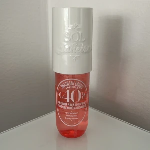 Sol de Janeiro Cheirosa 40 Perfume Mist - Parfymmist från Sol de Janeiro, Cheirosa 40, med doft av black amber plum och vanilla woods. Flaskan är cylinderformad med en vit plastkork och transparent rosa plastflaska. Rymmer 90 ml och har en fräsch, söt och varm doftprofil.