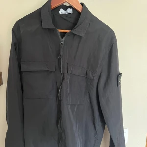Stone Island Jacka - Säljer en svart Stone Island jacka! Jackan är i bra skick. Jackan är inte riktig därmed kan pris diskuteras.