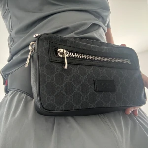 Svart Gucci axelväska med GG-mönster - Säljer en svart axelväska från Gucci. Använd i 2 veckor skick 10/10. Finns låda o påse till. 
