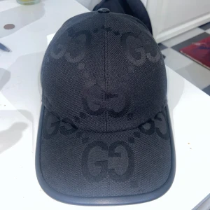 Jumbo gucci keps - Svart Jumbo Gucci-keps, storlek M. Aldrig använd, i toppskick. Kolla bilderna noga innan köp – inga returer. Frakt inom 24h. Pris är inte hugget i sten. DM vid intresse. 