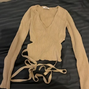 Beige ribbad omlottopp från Adorn - Har använt den några gånger. Minns ej storleken men den passar för Xs och S