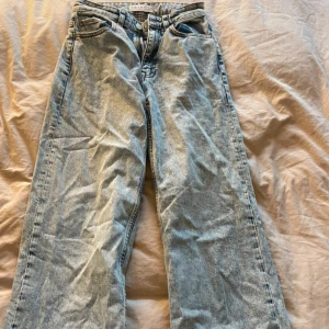 Ljusblå wide jeans från Primark - Ljusblå jeans från Primark med rak och lite vidare passform. Hög midja och klassisk femficksdesign. Jeansen har råa, fransiga benslut för en avslappnad vibe. Tillverkade i denim med dragkedja och knapp framtill. Legat i garderoben så därav lite skrynkliga.