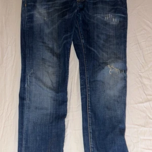 Dsquared2 Cool Guy blå jeans - Snygga Dsquared2 Cool Guy jeans i klassisk blå. Raka ben och normal passform, tillverkade i bomull. Perfekta för dig som gillar en avslappnad men trendig stil. OBS! Pris kan diskuteras