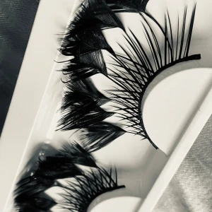 Prisförslag- 1 par Dramatiska lösögonfransar i svart - ett par riktigt dramatiska lösögonfransar i svart med fjäderliknande design och extra långa, spretiga strån. Fransarna har en unik form med både täta och glesa partier för en maxad effekt. Perfekta för dig som vill sticka ut och skapa en riktigt cool look.