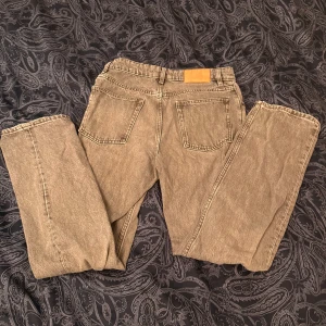 Grå jeans från Zara, straight fit - Säljer ett par grå jeans från Zara i rak modell med klassisk femficksdesign och knappgylf. Jeansen har bälteshällor och är tillverkade i denim. Perfekta för en chill och stilren look.