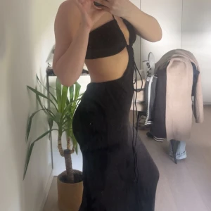 Sommar klänning - Supersnygg svart långklänning med cut out-detaljer i midjan och snörning framtill. Klänningen är ärmlös och har halterneck med smala band som knyts i nacken. Perfekt för sommar , nytt 