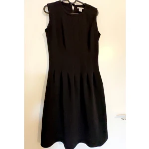 Svart ärmlös klänning från H&M - Klassisk svart klänning från H&M i storlek 36. Den är ärmlös med rund halsringning och har veckad kjol som ger en snygg siluett. Dragkedja i ryggen för enkel påklädning. Perfekt för dig som gillar stilrena och tidlösa plagg.