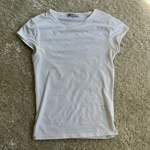 Vit basic t-shirt från Zara - Enkel och stilren vit t-shirt från Zara i klassisk modell. T-shirten har rund halsringning och korta ärmar. Materialet är mjukt och stretchigt, perfekt för en clean och fräsch look. Passar till allt och är ett måste i garderoben. Det finns en liten fläck som visas på bild 3.🤗