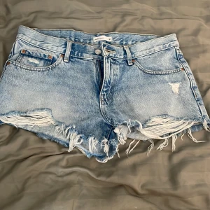 Ljusblå jeansshorts  - Snygga ljusblå jeansshorts från Gina tricot. Säljs eftersom de är för stora. Kan även tänka mig att byta ifall någon har de i storlek 36. 